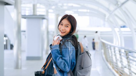 Young asian woman using headphone for listening nice music and walking in city. Girl happiness, smile face. Female love listen music that make her relax and enjoying life