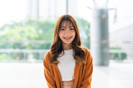 Téléchargez les photos : Portrait de jeune femme asiatique beauté souriant et regardant la caméra, debout dans la tour moderne de construction - en image libre de droit