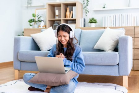 Photo for Young Asian Woman Having a Video Call on Laptop in a Cozy Home Office - Remote Work and Technology Concept - Royalty Free Image