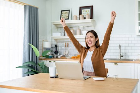 Photo for Funny euphoric young asian woman celebrating winning or getting ecommerce shopping offer on computer laptop. Excited happy girl winner looking at notebook celebrating success - Royalty Free Image
