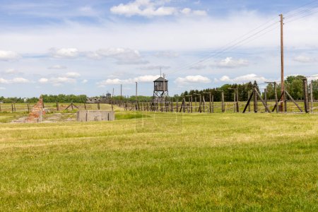 Foto de Majdanek; Lublin; Poland - May 25, 2022: Majdanek concentration and extermination camp, view on barbed wire fence and guard tower. It was a Nazi camp built and operated by the SS during the German occupation of Poland in World War II - Imagen libre de derechos