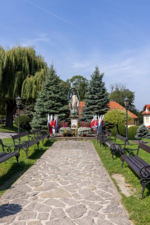 Photo for Kalwaria Zebrzydowska, Poland - August 18, 2022: Figure of Mary on courtyard in front of Pilgrim's House and 17th century Passion and Marian sanctuary - Royalty Free Image