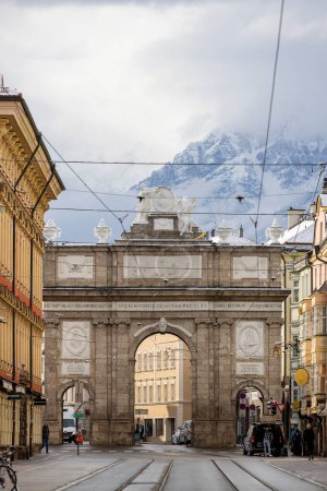 Foto de Innsbruck, Austria - 26 de febrero de 2023: Arco triunfal (Triumphpforte) en la calle Maria Teresa. Fue construido en 1765 para celebrar la boda del Archiduque Leopoldo y María Luisa. - Imagen libre de derechos