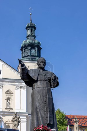 Photo for Kalwaria Zebrzydowska, Poland - August 18, 2022: Sculpture of Pope John Paul II on Paradise Square in front of 17th century Passion and Marian sanctuary of Bernardine Fathers - Royalty Free Image