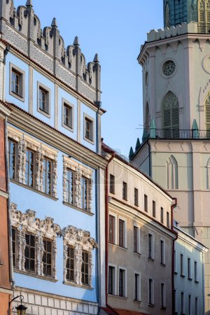 Foto de Lublin, Polonia - 23 de mayo de 2022: Torre Trinitaria, vista desde la Plaza de la Ciudad Vieja y casas de viviendas decorativas medievales. La torre tiene dos fachadas del mismo diseño, frente al casco antiguo y la Plaza de la Catedral. - Imagen libre de derechos