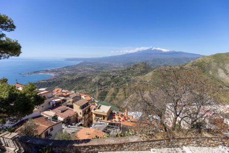 Foto de Castelmola, Sicilia, Italia - 28 de abril de 2023: Vista aérea de la ciudad y sus alrededores en la bahía del Mar Jónico desde el Castillo de Mola. Monte Etna volcán en una instancia - Imagen libre de derechos