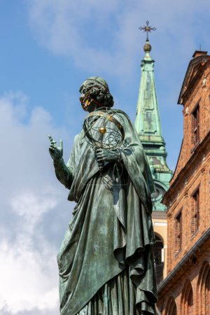 Téléchargez les photos : Torun, Pologne - 26 juin 2020 : Monument Nicolaus Copernicus, statue de l'astronome de la Renaissance polonaise sur la place de la Vieille Ville en face de la mairie. Sculpture avec masque de protection, temps pandémique Covid-19 - en image libre de droit