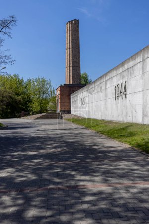 Foto de Lodz, Polonia - 4 de mayo de 2023: Estación de tren de Radegast, lugar de deportación de judíos a campos de concentración nazis alemanes. Alley of Remembrance of the Victims of the Lodz Ghetto. Chimenea simbólica de crematorio - Imagen libre de derechos