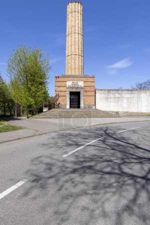 Foto de Lodz, Polonia - 4 de mayo de 2023: Estación de tren de Radegast, lugar conmemorativo de los judíos deportados a los campos de concentración nazis alemanes desde el gueto de Lodz (Gueto de Litzmannstadt). Chimenea simbólica de crematorio - Imagen libre de derechos