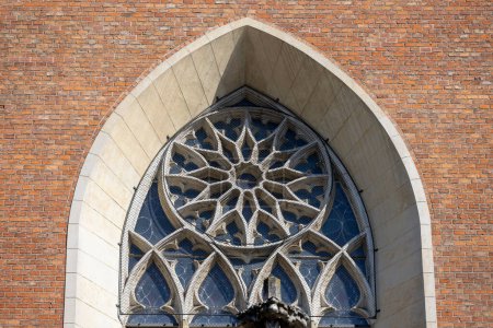 Photo for Krakow, Poland - September 6, 2023: Medieval Basilica of Holy Trinity Catholic church located at Stolarska Street in the Old. Rose window at facade - Royalty Free Image