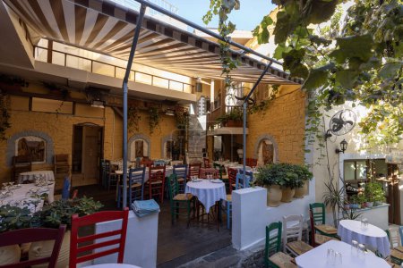 Téléchargez les photos : Athènes, Grèce - 19 octobre 2022 : Restaurant extérieur sur les escaliers sur le chemin de l'Acropole dans le quartier de Plaka. Tables recouvertes de nappes blanches - en image libre de droit