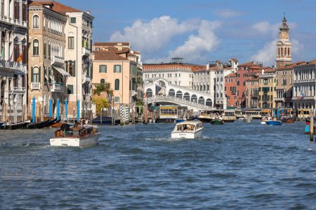 Téléchargez les photos : Venise, Italie - 27 septembre 2023 : Grand Canal, maisons historiques décoratives au bord de l'eau, bateaux flottants. Pont du Rialto (Ponte de Rialto) à distance - en image libre de droit