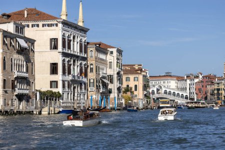 Téléchargez les photos : Venise, Italie - 27 septembre 2023 : Grand Canal, maisons historiques décoratives au bord de l'eau, bateaux flottants. Pont du Rialto (Ponte de Rialto) à distance - en image libre de droit