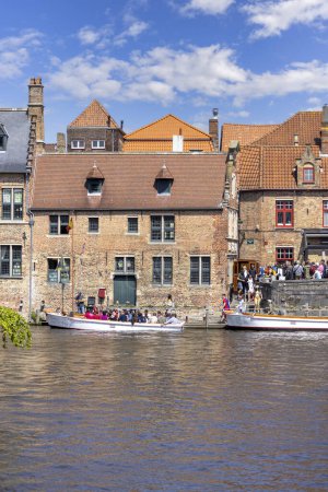 Foto de Brujas, Bélgica - 19 de mayo de 2023: Los turistas esperan en puerto en Rosary Quay para un viaje en barco para un crucero por el canal de agua - Imagen libre de derechos