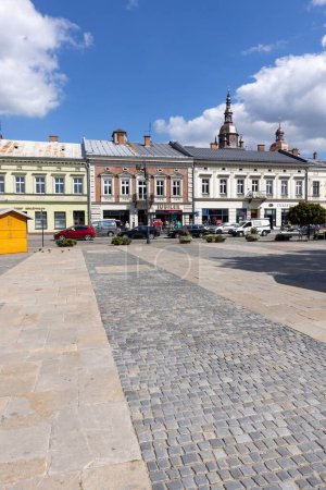Photo for Nowy Sacz, Poland - August 30, 2022: View of Market Square on a sunny day. It is a city in the Lesser Poland Voivodeship in the south of the country. Towers of the Collegiate Basilica of St. Malgorzata in a distance - Royalty Free Image