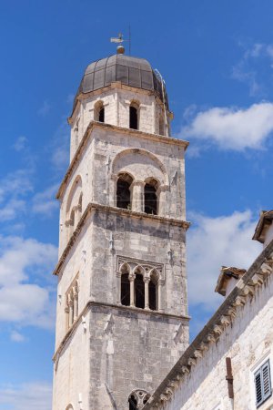 Téléchargez les photos : Dubrovnik, Croatie - 27 juin 2023 : Eglise médiévale Saint-François avec clocher située dans la rue principale Stradun près de l'entrée de la ville Pile Gate des murs de la ville - en image libre de droit