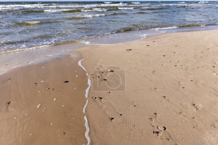 Vue pittoresque sur la plage de sable de la mer Baltique, eau mousseuse coulant dans le sable, île Wolin, Miedzyzdroje, Pologne