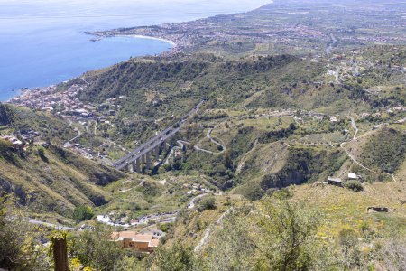 Luftaufnahme der Stadt an der Bucht des Ionischen Meeres vom Schloss von Mola, Castelmola, Sizilien, Italien. Autobahn A18 Messina - Catania Viadukt