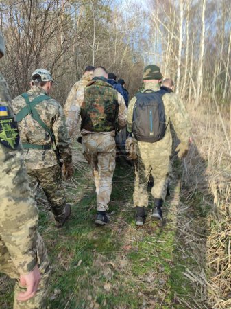 Foto de Los soldados llevan a los heridos en el bosque - Imagen libre de derechos