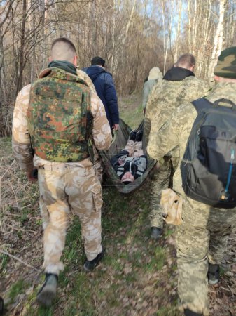 Téléchargez les photos : Les soldats portent les blessés dans la forêt - en image libre de droit