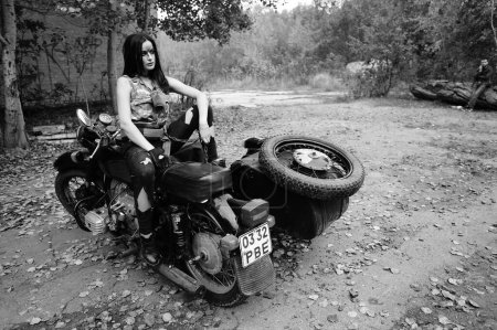 Photo for Black-white photo of a girl on a motorcycle in the forest - Royalty Free Image