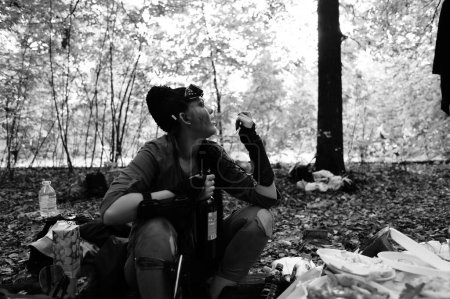 Téléchargez les photos : Jeune femme avec une bouteille de vin dans le parc - en image libre de droit