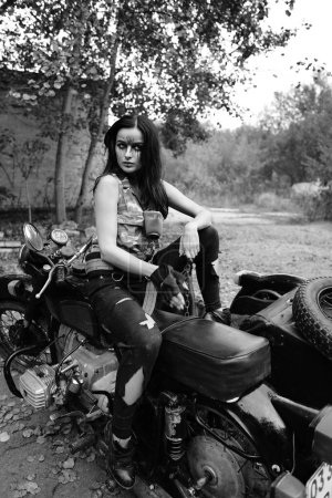 Téléchargez les photos : Photo noir-blanc d'une fille sur une moto dans la forêt - en image libre de droit