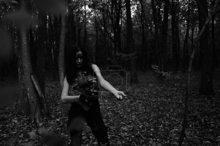 Téléchargez les photos : Photo noir-blanc d'une fille guerrière avec chaîne dans la forêt - en image libre de droit