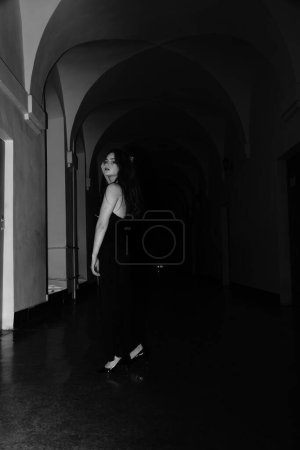 Foto de Foto en blanco y negro de una hermosa mujer sensual en un vestido negro posando para la cámara - Imagen libre de derechos