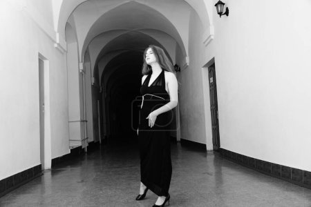 Foto de Foto en blanco y negro de una hermosa mujer sensual en un vestido negro posando para la cámara - Imagen libre de derechos