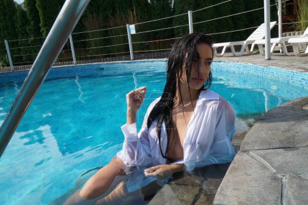 Foto de Sexy chica en lencería y una camisa blanca en una piscina - Imagen libre de derechos