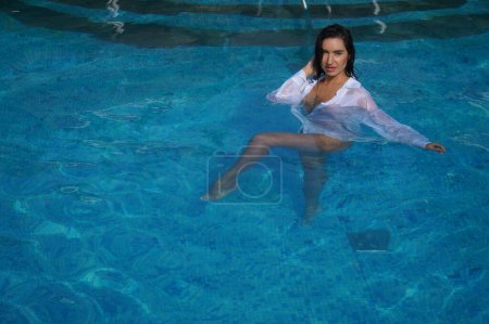 Téléchargez les photos : Fille sexy dans une chemise blanche dans une piscine - en image libre de droit