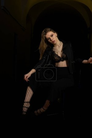 Photo for Girl in black and white clothes on the background of a wall with black lights. - Royalty Free Image
