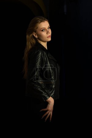Téléchargez les photos : Portrait d'une belle fille en veste noire sur fond sombre. - en image libre de droit