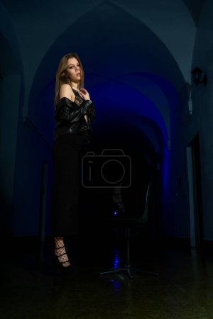 Photo for Beautiful young woman in black dress posing in studio - Royalty Free Image