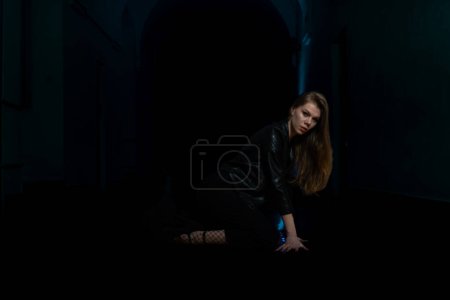Téléchargez les photos : Portrait d'une belle jeune fille sensuelle posant dans un intérieur sombre. Photo de mode. - en image libre de droit