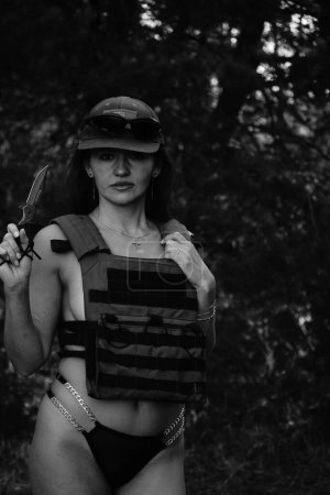 Foto de Foto en blanco y negro de una chica soldado medio desnuda en el bosque - Imagen libre de derechos