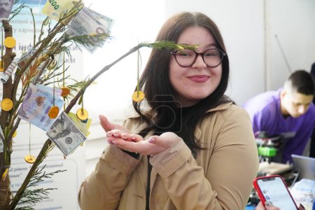 Foto de Lutsk, Ucrania: mujer cerca de árbol de dinero en la ceremonia de premiación de estudiantes el 8 de marzo en Volyn Professional College de la Universidad Nacional de Tecnologías Alimentarias - Imagen libre de derechos