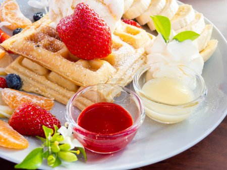 Téléchargez les photos : Gaufre avec crème glacée et fruits sur table en bois, vue de dessus - en image libre de droit