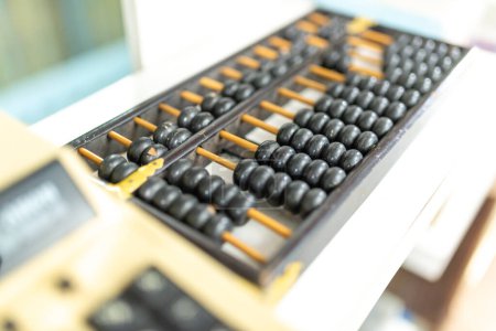 abacus and calculator on the table in the office, business concept