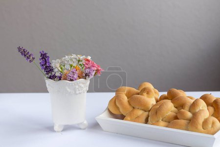 Foto de Ramo de flores silvestres y pasteles frescos. pretzels para el desayuno - Imagen libre de derechos
