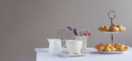 Foto de Ramo de flores silvestres y pasteles frescos. Pretzels para el desayuno. Una taza de café. - Imagen libre de derechos