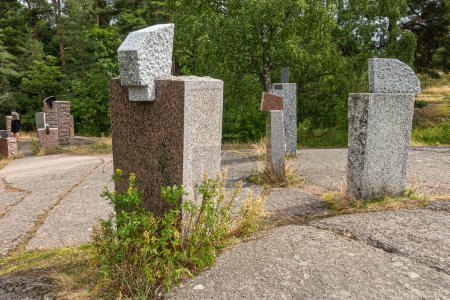 Photo for Finland, Kotka - July 18, 2022: Sopokanlahti park and lake. Collection, Brown and gray modern sculpted marble rock blocks as art on plateau under gray cloudscape. Green belt as backdrop - Royalty Free Image