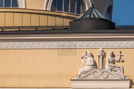 Téléchargez les photos : Helsinki, Finlande - 19 juillet 2022 : Frise sculptée en gros plan sur la façade jaune de la Bibliothèque nationale avec Lady Justice et femme en croix. - en image libre de droit