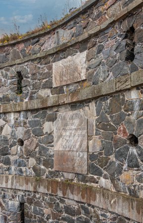 Foto de Helsinki, Finlandia - 19 de julio de 2022: Fortaleza Suomenlinna. Primer plano, placa conmemorativa del rey Fredrik colocada en muralla de piedra gris en la Puerta Real - Imagen libre de derechos
