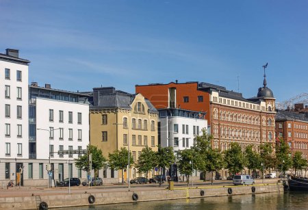 Photo for Helsinki, Finland - July 20, 2022: Pohjoissatama Harbor. Facades on west side with Lithuania Embassy and other buildings, one historic with corner lookout tower under blue sky - Royalty Free Image