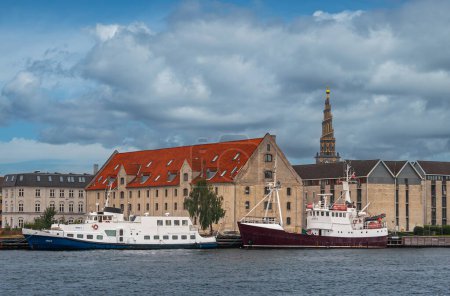 Téléchargez les photos : Copenhague, Danemark - 12 septembre 2010 : Vue vers le sud depuis Havnepromenade à Nyhavn montre des entrepôts historiques, maintenant résidentiels et bureaux. Derrière, église de notre tour de Sauveur - en image libre de droit