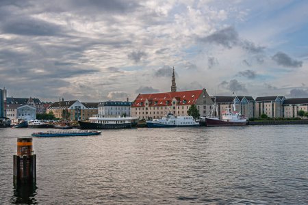 Téléchargez les photos : Copenhague, Danemark - 12 septembre 2010 : Vue sud depuis Havnepromenade à Nyhavn montre les entrepôts historiques, maintenant résidentiels et bateaux. Derrière, église de notre tour de Sauveur - en image libre de droit