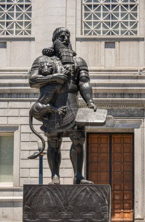 Photo for San Francisco, CA, USA - July 12, 2023: Closeup, Statue of historic Ashurbanipal Assyrian king or Enkidu holding a wriggling lion and a tablet, at south facade of Asian Art Museum. - Royalty Free Image