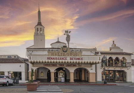Foto de Santa Barbara, CA, Estados Unidos - 19 de enero de 2024: La fachada frontal del Teatro Arlington en State Street bajo nubes de color al atardecer. Torre atrás, coche en la calle - Imagen libre de derechos